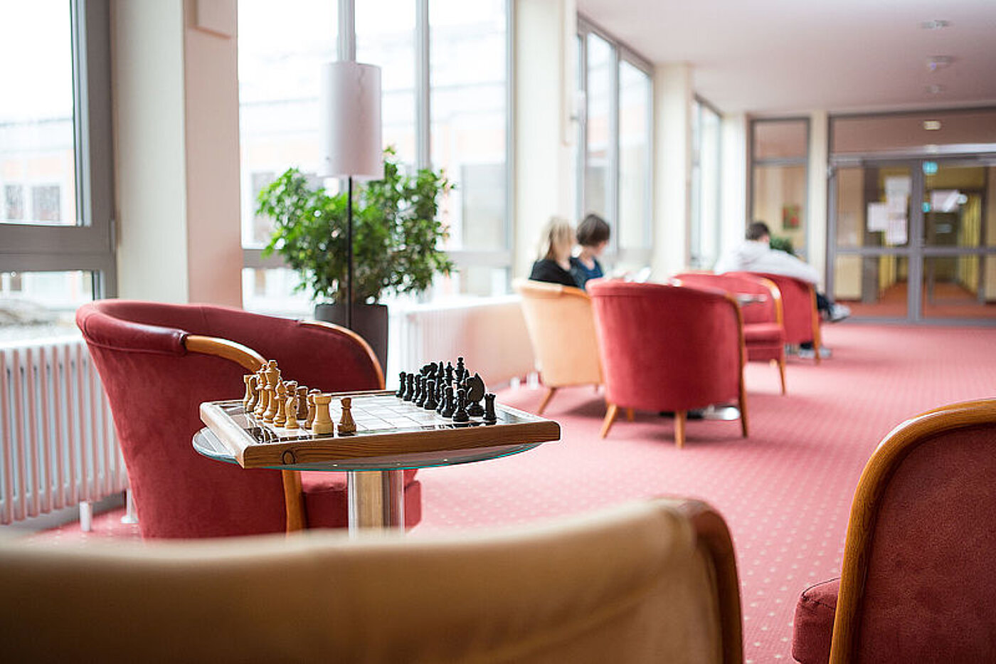 Leseraum mit verschiedenen kleinen Sitzgruppen, Schachbrettspiel auf einem Tisch